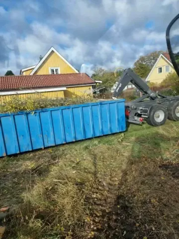 Lastmaskin vid container - mark- och anläggningsarbeten